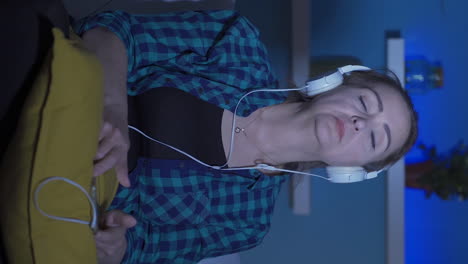 Vertical-video-of-Depressed-woman-listening-to-music-at-home-at-night.